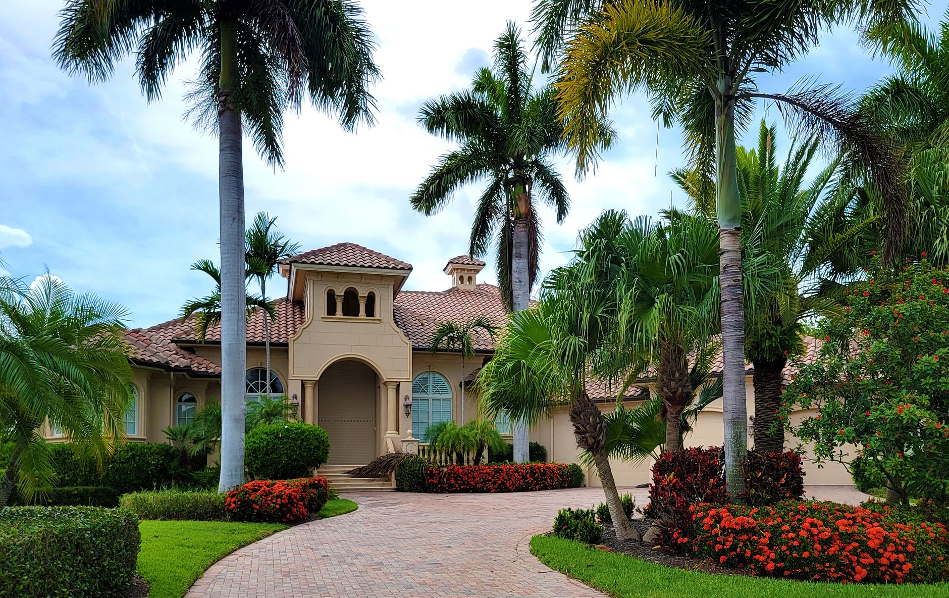 Elegant Port St Lucie home with lush palm trees and a fully landscaped front garden